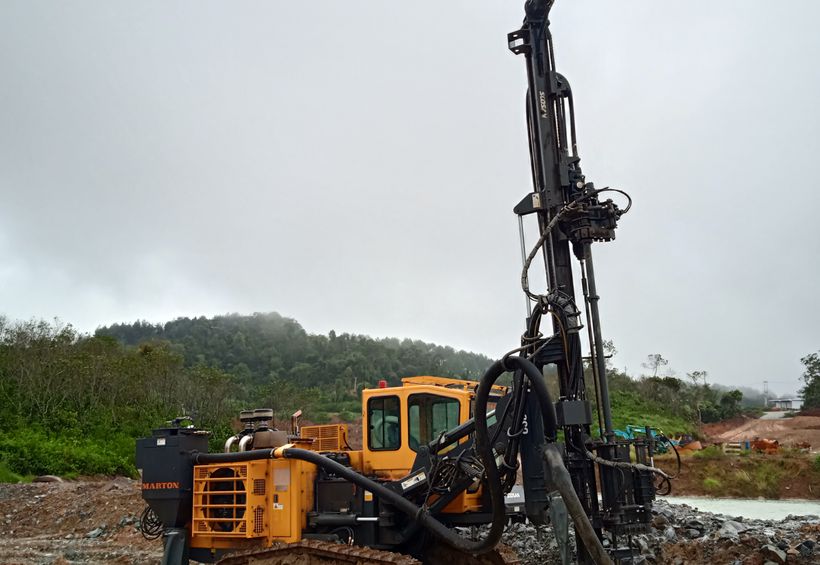 Drilling rig running deeper on a rocky Kerr County site with Hill Country slopes behind
